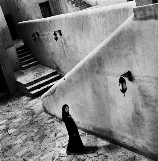 A young lady from Syria appreciates quiet and peaceful moment at courtyard of Nizwa Fort, Oman. Women can hardly be seen alone on streets here. Adjusting to a new life in more restricted country and dealing with a feeling of isolation is her own fight. 
