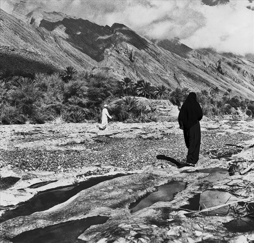 A woman in black Abaya walks in Wadi in Nizwa, Oman. This small village surrounded by dynamic landscape of Wadi is where she has spent whole her life. Life for a mother of 3 is fairly quiet but peaceful. Visiting her relatives has become more frequent routine after her husband death
