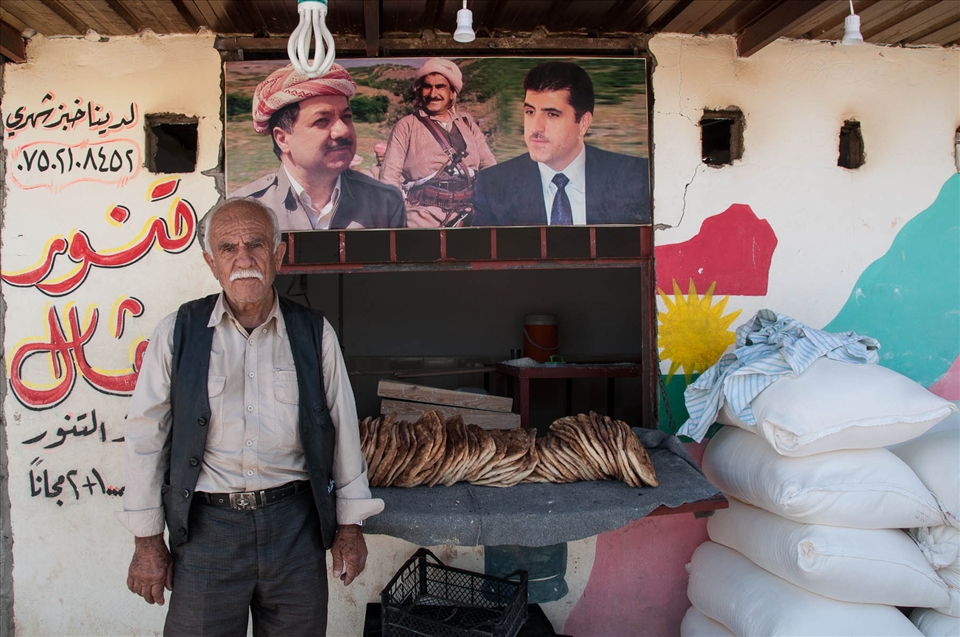 People try to go on with their lives and do what they did before escaping from their villages. This man is 72 years old and left Syria at a sudden with his son. They had a bakery  that has been destroyed and they have now arranged their new shop in an emergency building, decorated with a painting of the Kurdish flag  and the picture of Masoud Barzani, the founder of the democratic Party of Kurdistan and President of the Kurdish Autonomous Region of Iraq. He gives pitas, the local bread, for free to all refugees who cannot afford to pay for it.