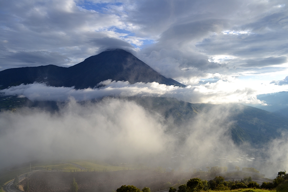 Active volcano near Banos, surrounded by low clouds.