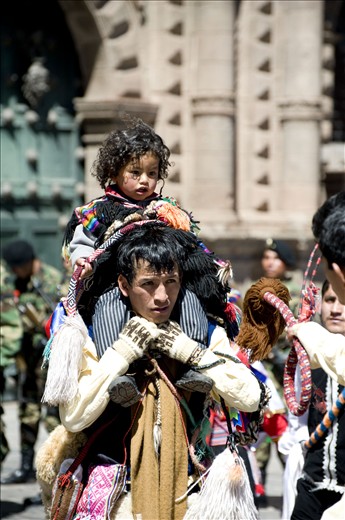 A father and son pair wait for their turn to perfom in the same parade.