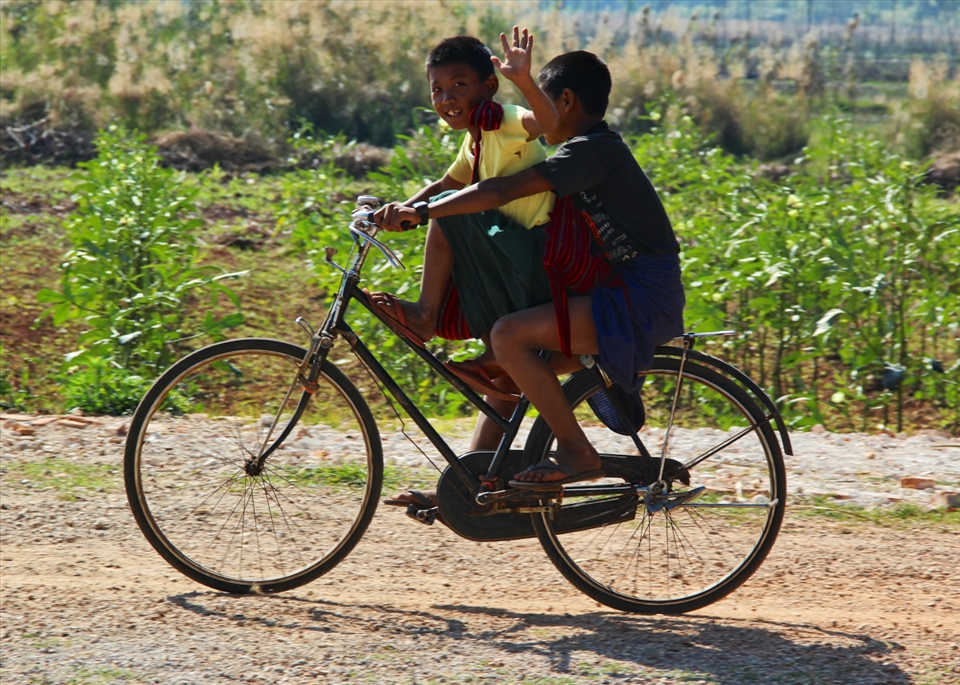 Local village boys share a bike ride to school 