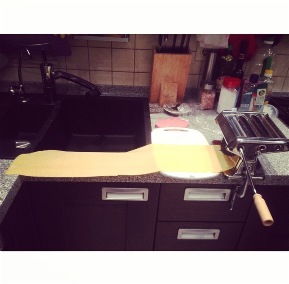 Rolling the dough through pasta machine