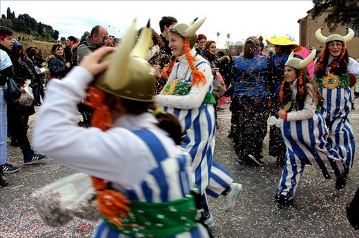 Romans celebrate Carnival in the street, with different, colorful costumes. 