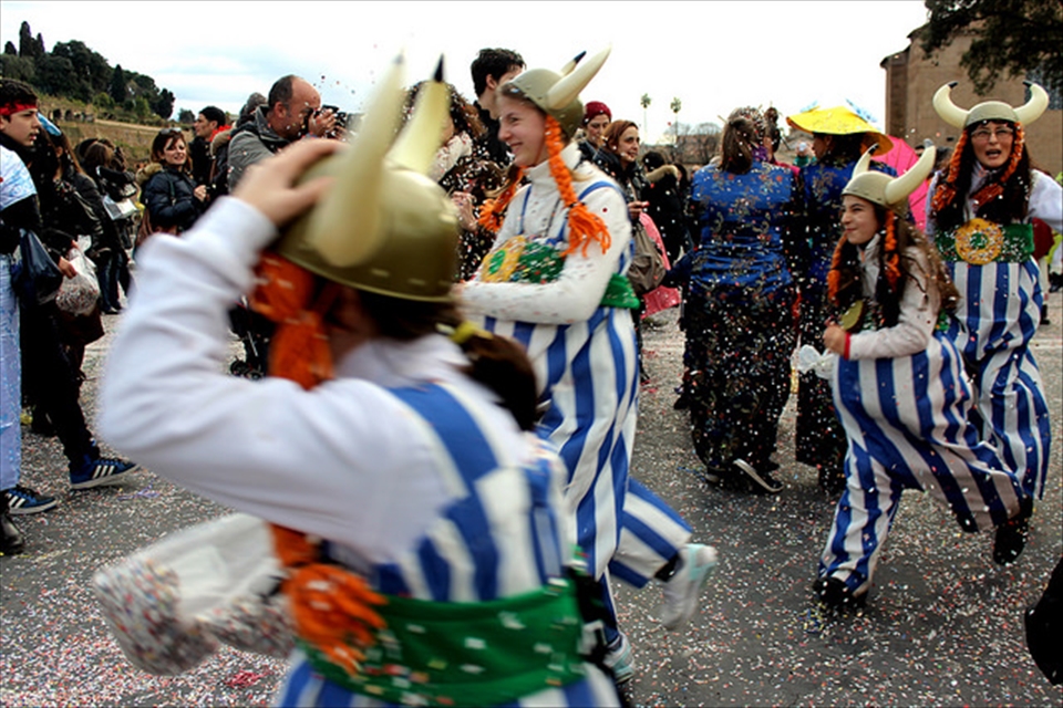 Romans celebrate Carnival in the street, with different, colorful costumes. 