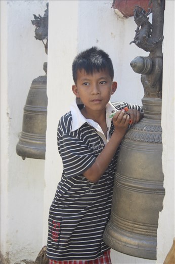 A young Burmese boy plays with a laser pen near a popular pagoda in Bagan.