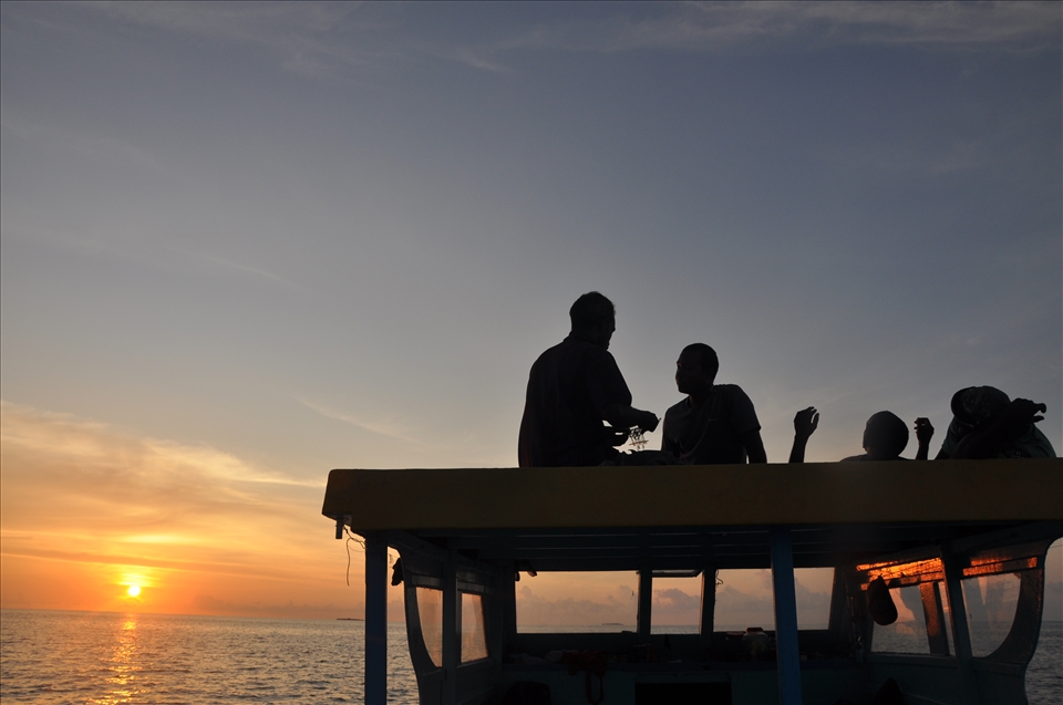 These men wait to pray at sunset before they begin their night fishing.