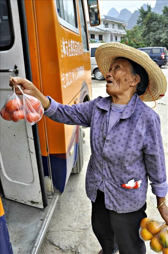A woman making her living out of selling clementines to tourists.