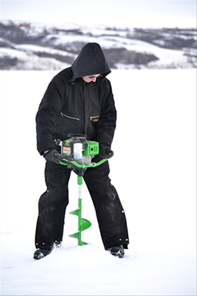 With a gasoline driven ice auger Ron drills several ice fishing holes. 