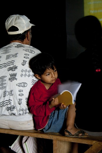 A boy flicks through a book during a coffee seminar
