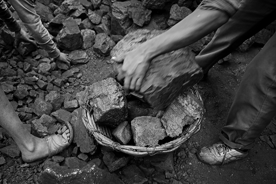 Pieces of coal and loading into wicker baskets for sell at black market.