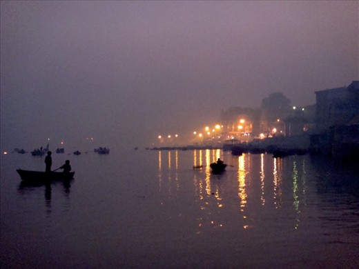 This photo was taken from a boat approaching the Dasashvamedha ghat where priests perform ritual prayers for the pilgrims. On the river there are boats with people offering oil lamps and flowers to the holy river Ganges.  