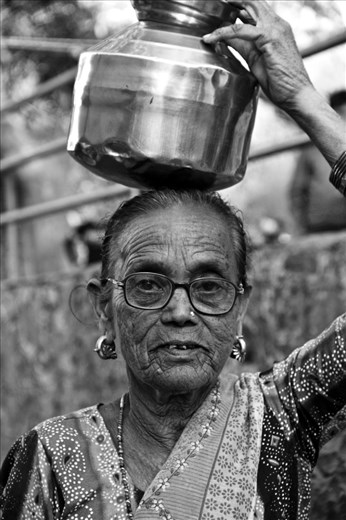 Woman carrying a jug of water home. Seen on Elephanta Island, Mumbai, India.