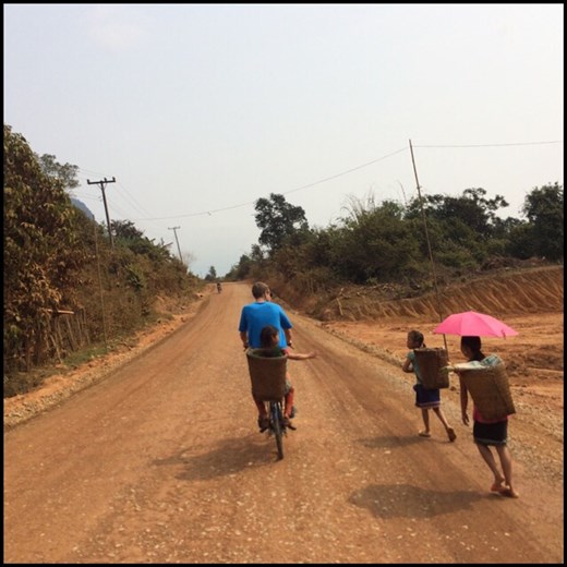 Kurt transportant sur son vélo sans vitesse une petite fille fatiguée de marcher. 