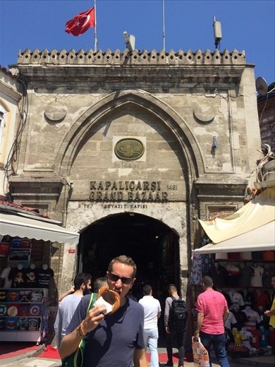 En train de manger un simit, genre de bretzel géant qui se vend partout dans les rues. Photo prise devant le grand bazar qui est l'un des plus grands bazars au monde, réparti sur 200 000 m², possédant 4 000 boutiques, situé le long de 58 rues intérieures auxquelles on accède par 18 portes. 