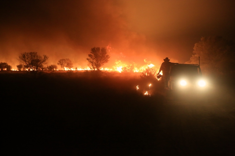 Back burning to try and protect a fence line. Back burners work in teams of 2 with the person operating the drip torch hanging on to the side of a vehicle to cover more ground. 