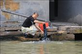 A woman cleans her clothes in outside of her back door in an unsanitary area of the Grand Canal: by firstimpressions, Views[755]