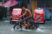 Young man riding his bicycle in the flood: by flood_in_manila, Views[283]