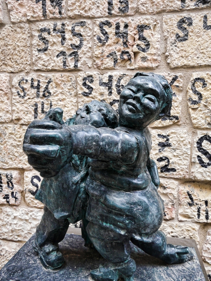 Street Art on the Alrov Mamilla Avenue with painted numbers on each of the building’s stones in the background, witness to the conservation work that included dismantling of the structures, storage of the stones and their accurate reassembly afterwards.