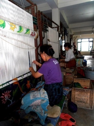 Note the pattern on the roll above  the weaver's head. 