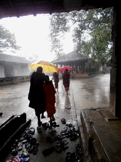 Monks caught in the rain at Ammbekka temple near Kandy