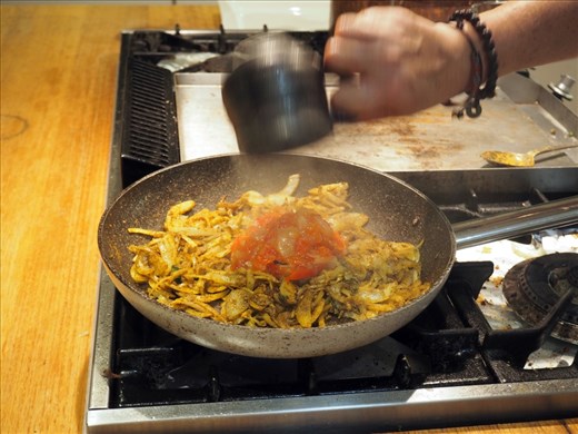 Frying onions in ghee and adding tomato chutney