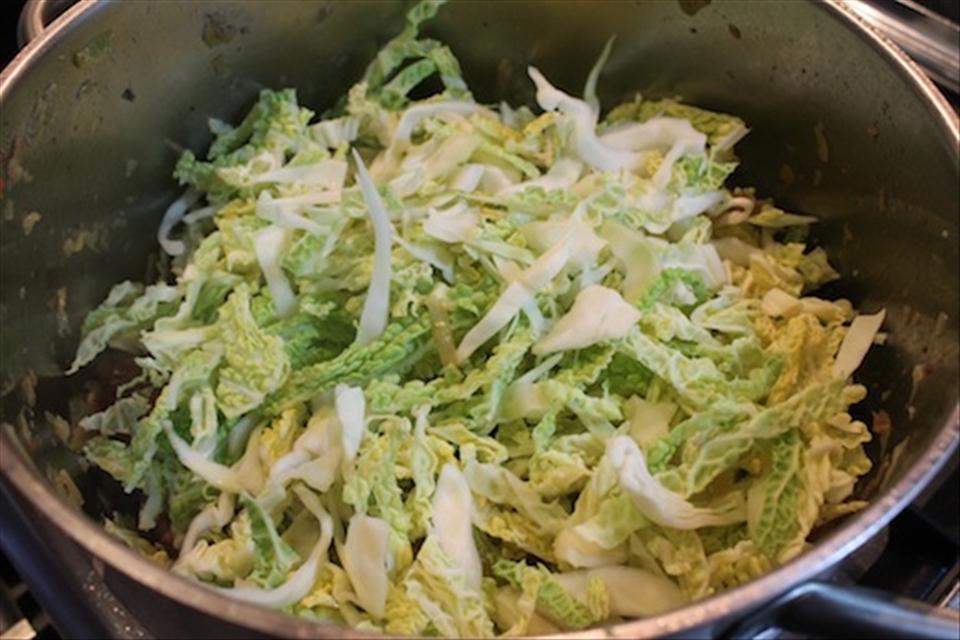 Add the pork back to the pot. Top with 1/3 of the cabbage. Cook until wilted.