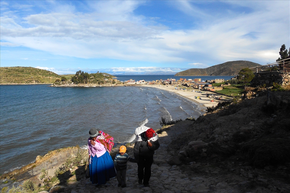 Life: the old and the young. Family on Christmas day, 'Isla del Sol', near Lake Titicaca. Even during festivities Bolivians do not abandon their duties and hard work. 