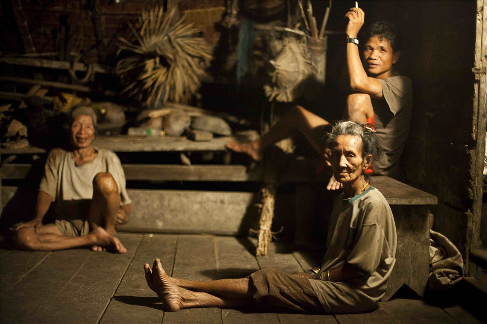 This woman and her husband (left) were only able to bear only one child; a girl. As is customary with the Mentawaians, their daughter lives with her husband, many hours’ walk from her family home. As the couple have grown older and having no children present to assist them with their day-to-day tasks, the temptation to resettle into a government village with fewer physical demands became difficult to resist. But in modern village people will encounter modern problems; food must be purchased using money within the village. As soon as government funding draws to a close, generating a sustainable income becomes a near-impossible task. Thus, they move back.  In the jungle money is not required. There is always shelter and food is plentiful. For this couple despite having a “modern” house in a village it is their jungle home that still remains integral to their survival.