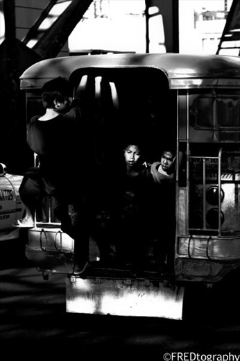 Street children hitch a free ride in one of the jeepneys in Manila. 

This image is particularly catchy because of the way the light falls on the kid's face. 