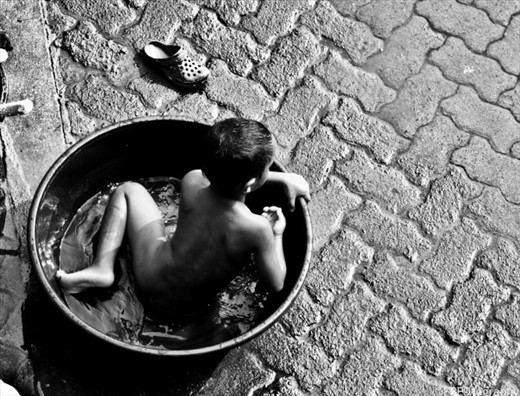 This kid was bathing himself in a pale of water while watching his mom clean the house. He was so happy in it. Scattering water everywhere, same as one would do when in the beach. Such simple means of happiness.
