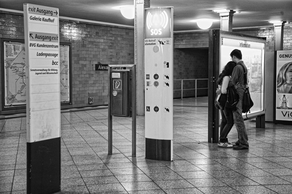Couple exchanging kisses while they wait for the train
