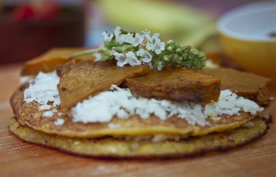 Cachapa in detail with a basil flower.