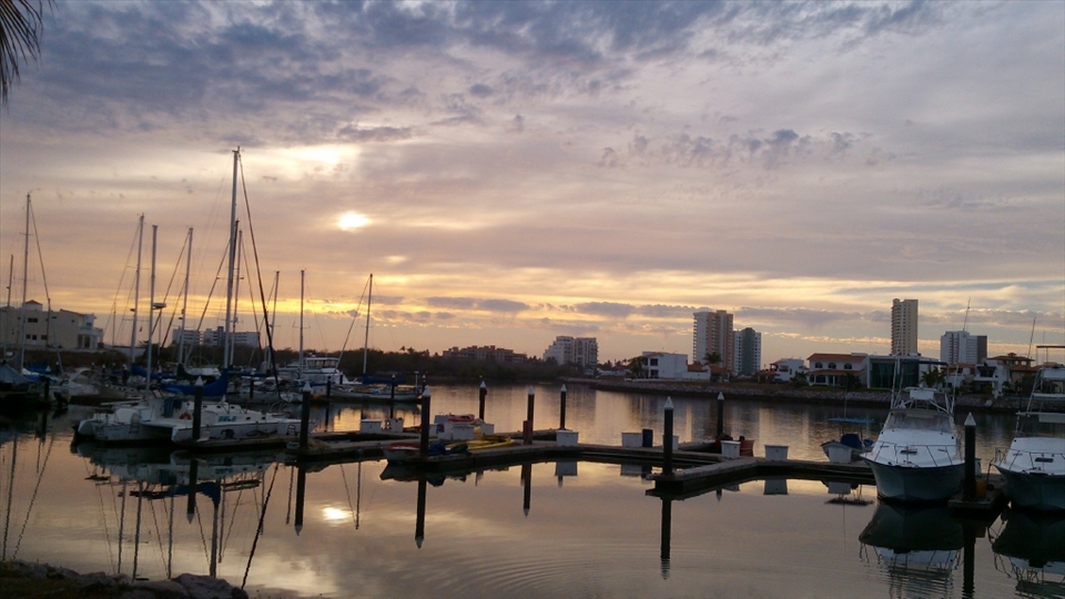 A cloudy day while I walk and see the sun reflected on the water. 