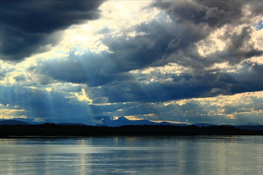The sun's rays shining down through clouds on to the Hastings river at Port Macquarie. A large dolphin packed river on the mid north coast of NSW Australia.