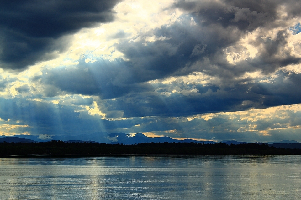 The sun's rays shining down through clouds on to the Hastings river at Port Macquarie. A large dolphin packed river on the mid north coast of NSW Australia.