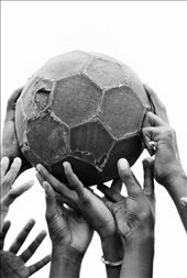 Hold what is important up high. A bunch of children hold up their tattered ball.: by geeejay, Views[438]