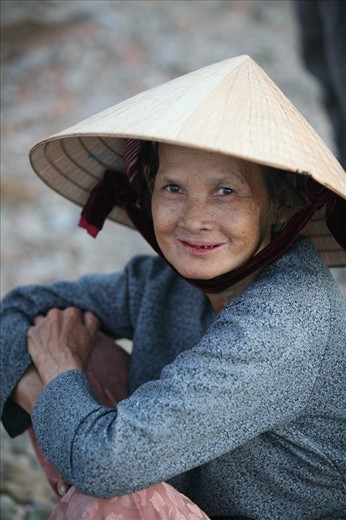 This beautiful Vietnamese woman wearing traditional conical straw hat has seen several sunrises waiting for the men to return from the South China Sea with their catch.
