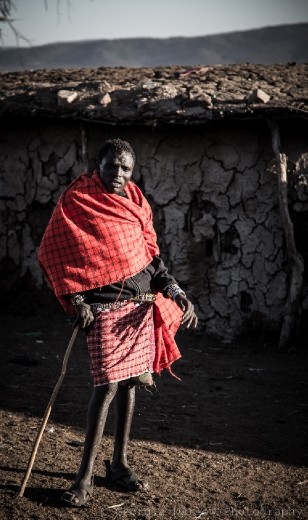 A Maasai tribesman stands near his hut in the Maasai Mara, Kenya