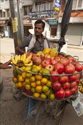 Pop up Shop.
Discovering the colourful and dusty streets one morning in Thamel, I come across a farmer selling fruit to a tourist-populated hotspot. His impressive mobile shop allows fruit to be sold whilst on the move, traveling to the markets and restaurants scattered in the Valley. Custom made circular panniers are constructed using old pipe and fish net which allow him to carry larger loads than those still carting traditional timber boxes. The shop also carries a set of scales for accurately measuring desired quantities. 
: by gezismxavier, Views[465]
