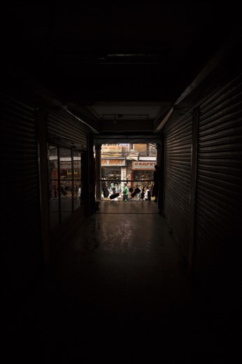 Selling music to the Dark.
Seeking shelter from Pokhara's daytime heat, an enclosed mall leads me off the main street. Here, at the end sat a tiny, traditional music shop, complete with a pipe smoking owner and skipping discman. Dusty, handcrafted instruments hung for sale on the walls. An unfinished example of what was to become an instrument lay next him. With no intention to buy, I smile and leave feeling somewhat saddened by his visual surroundings. A long tunnel where he sat watching and waiting for someone to come in and purchase something. I imagined what it must have been like when business boomed for him in his busy years. 
