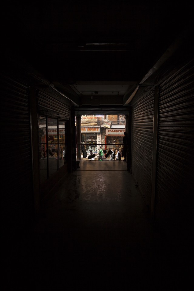 Selling music to the Dark.
Seeking shelter from Pokhara's daytime heat, an enclosed mall leads me off the main street. Here, at the end sat a tiny, traditional music shop, complete with a pipe smoking owner and skipping discman. Dusty, handcrafted instruments hung for sale on the walls. An unfinished example of what was to become an instrument lay next him. With no intention to buy, I smile and leave feeling somewhat saddened by his visual surroundings. A long tunnel where he sat watching and waiting for someone to come in and purchase something. I imagined what it must have been like when business boomed for him in his busy years. 
