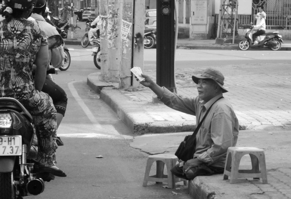 A guy - without legs - is selling lottery tickets on the street
