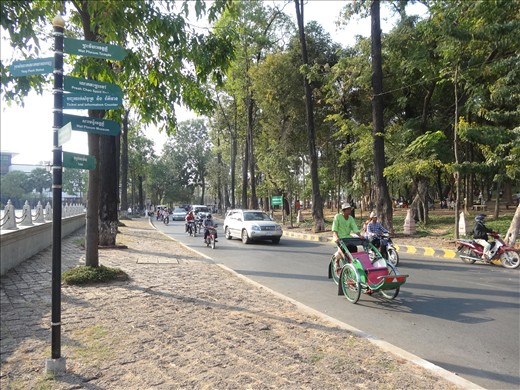 Near Wat Phnom - cyclos versus modern cars for transport!