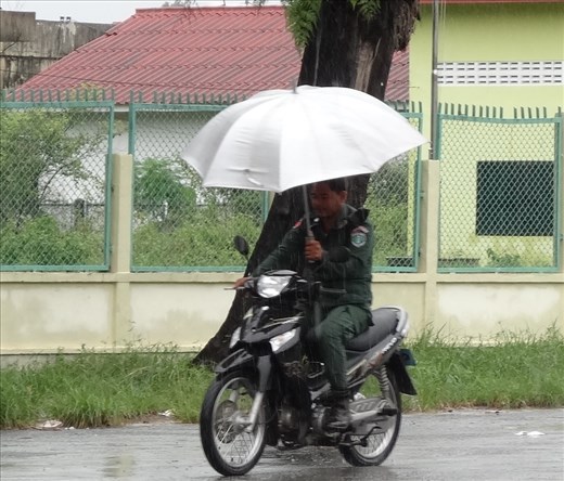 Military man uses umbrella as well