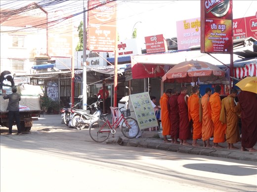 Monks line up for their morning collection from shops etc.
