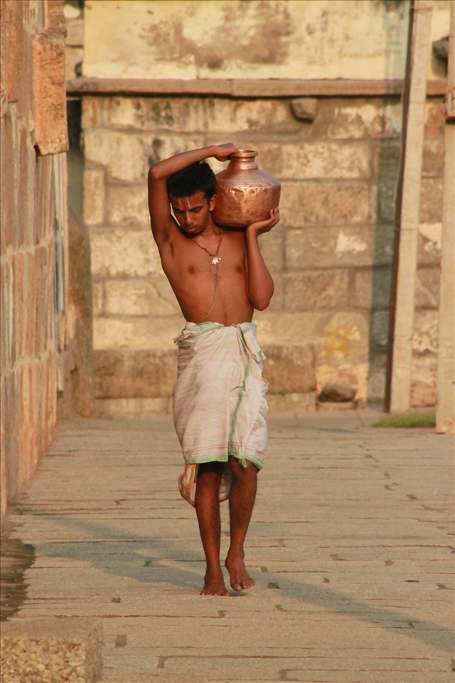 Man carries water into the temple for Puja.