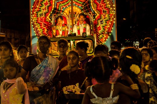 In the middle of busy traffic on a road in Pondicherry, a wedding procession proceeds, unperturbed as it adds to the street chaos and color. Pondicherry, India