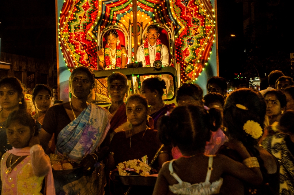 In the middle of busy traffic on a road in Pondicherry, a wedding procession proceeds, unperturbed as it adds to the street chaos and color. Pondicherry, India