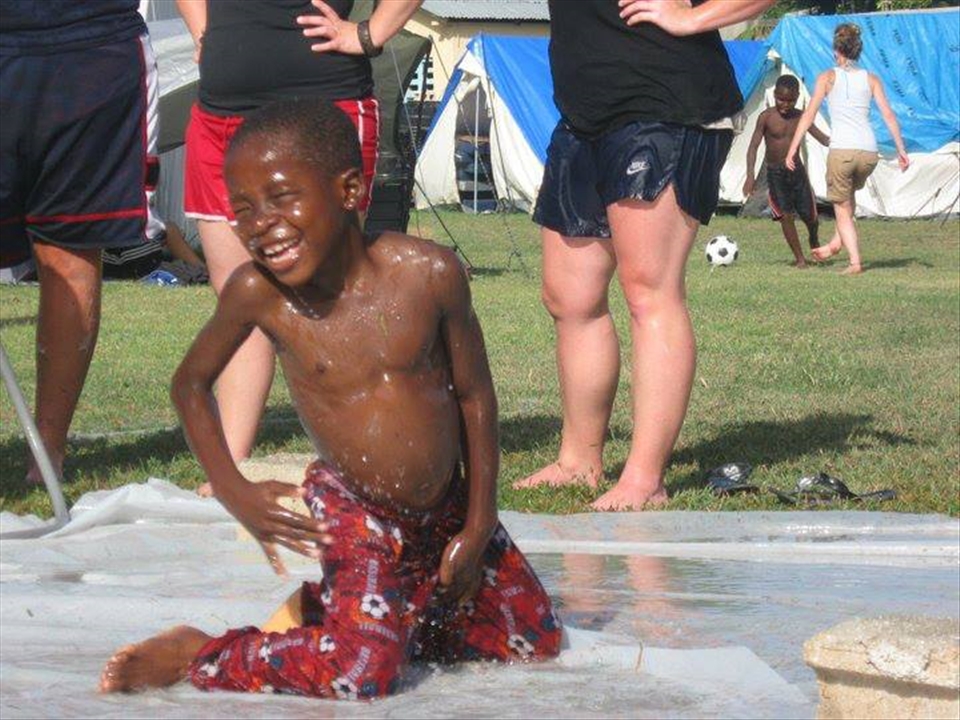 A Haitian child forgetting about what is outside the orphanage walls.